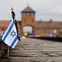 A small Israeli flag on the rail tracks at the site of the former Auschwitz-Birkenau camp during commemorations to honor the victims of the Holocaust, near the historic gate of Birkenau (Auschwitz II) near the village of Brzezinka near Oswiecim, Poland on April 28, 2022. (Wojtek Radwanski / AFP)