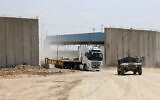 An Israeli military vehicle leads a truck in Beit Hanoun in the northern Gaza Strip during an operation to deliver humanitarian aid from Jordan to the coastal territory through the Erez Crossing, on May 1, 2024. (Jack Guez/ AFP)