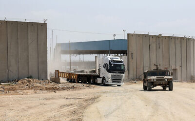 An Israeli military vehicle leads a truck in Beit Hanoun in the northern Gaza Strip during an operation to deliver humanitarian aid from Jordan to the coastal territory through the Erez Crossing, on May 1, 2024. (Jack Guez/ AFP)