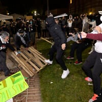 Counter-protesters clash with anti-Israel demonstrators at a pro-Palestinian encampment set up on the campus of the University of California Los Angeles (UCLA), in Los Angeles on May 1, 2024. (ETIENNE LAURENT / AFP)