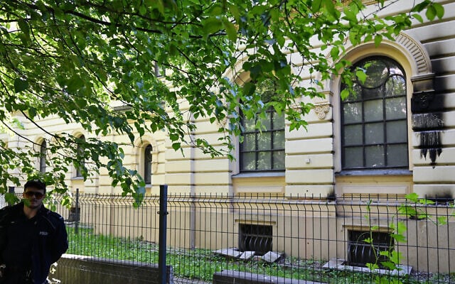 A Polish police officer stands guard outside the Nozyk Synagogue in Warsaw on May 1, 2024, after a Molotov cocktail was thrown at the building. (Photo by Sergei GAPON / AFP)