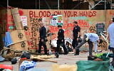 Police patrol as workers clean up anti-Israel graffiti at the University of California, Los Angeles (UCLA) campus after police evicted pro-Palestinian protesters, May 2, 2024. (Frederic J. Brown/AFP)