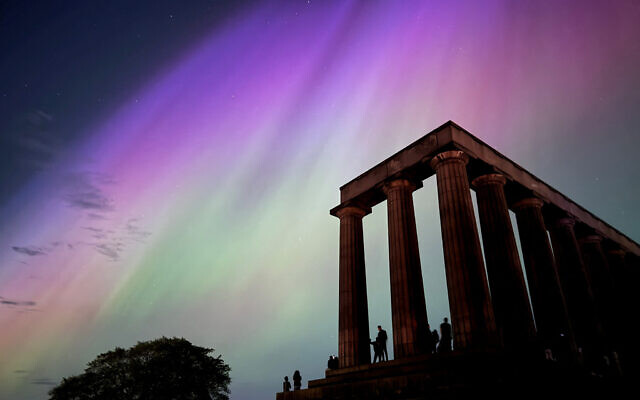 This handout photo taken and released by Jacob Anderson shows the northern lights or aurora borealis during a solar storm over the National Monument of Scotland in Edinburgh on May 10, 2024 (Handout / Jacob Anderson / AFP)