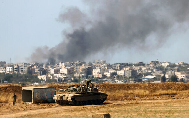 An Israeli tank is seen near the border with the Gaza Strip as smoke rises above the coastal enclave on May 15, 2024. (Jack Guez/AFP) An Israeli tank is seen near the border with the Gaza Strip as smoke rises above the coastal enclave on May 15, 2024. (Jack Guez/AFP)