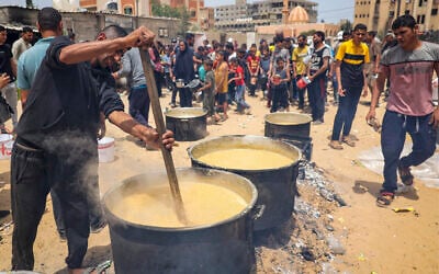 Volunteers prepare food for displaced Palestinians in Rafah, in the southern Gaza Strip, on May 19, 2024. (AFP)
