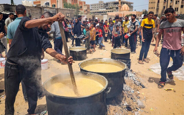 Volunteers prepare food for displaced Palestinians in Rafah, in the southern Gaza Strip, on May 19, 2024. (AFP)