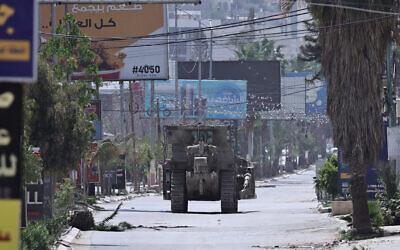 An Israeli army bulldozer advances through a deserted street during a raid in the West Bank city of Jenin, May 21, 2024. (Zain JAAFAR / AFP)