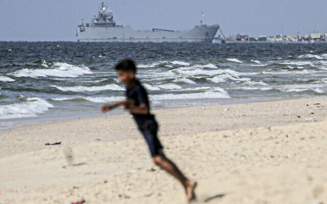 A child plays on a beach as a ship transporting international humanitarian aid is moored at the US-built Trident Pier near Nuseirat in the central Gaza Strip on May 21, 2024, amid the ongoing conflict between Israel and the Palestinian terror Hamas group. (AFP) A child plays on a beach as a ship transporting international humanitarian aid is moored at the US-built Trident Pier near Nuseirat in the central Gaza Strip on May 21, 2024, amid the ongoing conflict between Israel and the Palestinian terror Hamas group. (AFP)