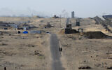 Two women walk on an asphalt road in the middle of a deserted camp for displaced Palestinians on the border with Egypt in Rafah in the southern Gaza Strip on May 22, 2024. (Eyad Baba/AFP)