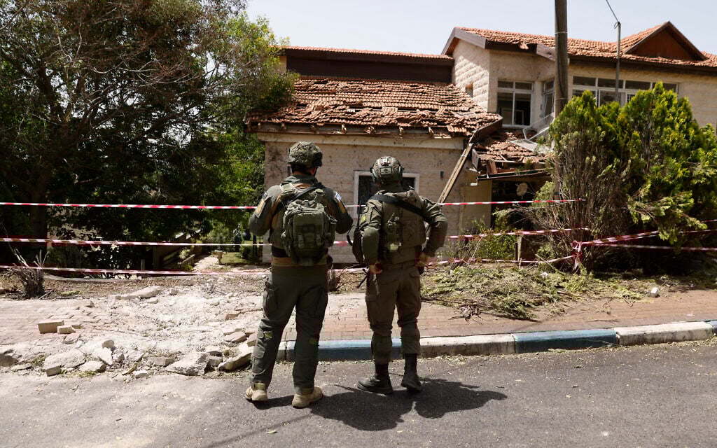Soldiers inspecting the damage to a building in the northern community of Dovev, after it was hit by rockets fired from Lebanon, during an IDF tour, on May 27, 2024. (Jalaa Marey/ AFP)