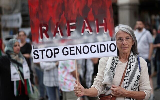 A protestor holds a sign reading "Rafah, Stop genocide" during a pro-Palestinian demonstration, in front of the Foreign Affairs ministry in Madrid, on May 27, 2024. - The Spanish government demanded on May 25 that Israel comply with an order by the top UN court to immediately stop its bombardment and ground assault on the Gazan city of Rafah. (Photo by Thomas COEX / AFP) A protestor holds a sign reading "Rafah, Stop genocide" during a pro-Palestinian demonstration, in front of the Foreign Affairs ministry in Madrid, on May 27, 2024. - The Spanish government demanded on May 25 that Israel comply with an order by the top UN court to immediately stop its bombardment and ground assault on the Gazan city of Rafah. (Photo by Thomas COEX / AFP)