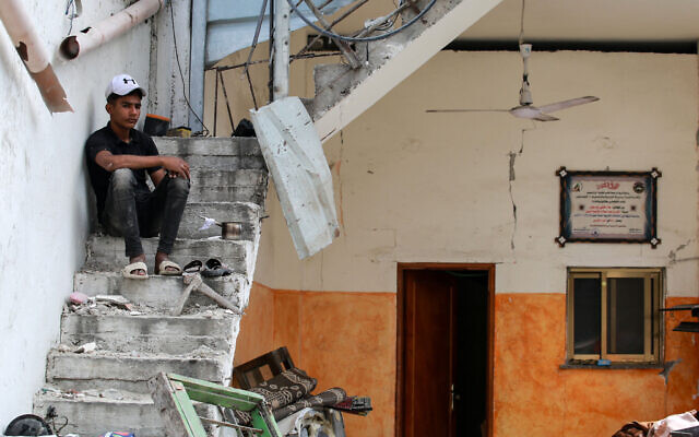 A Palestinian youth sits in a house hit during Israeli bombardment in Nuseirat, in the central Gaza Strip on May 30, 2024. (Bashar TALEB / AFP)