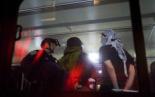 Members of the New York Police Department strategic response team load arrested protesters from Columbia University onto a bus, Tuesday, April 30, 2024, in New York (AP Photo/Julius Motal)