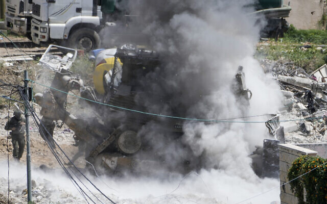 Smoke rises following explosions as Israeli soldiers take cover during a military operation in the Palestinian town of Dayr al-Ghusun, near the West Bank town of Tulkarem, May 4, 2024. (AP Photo/Majdi Mohammed) Smoke rises following explosions as Israeli soldiers take cover during a military operation in the Palestinian town of Dayr al-Ghusun, near the West Bank town of Tulkarem, May 4, 2024. (AP Photo/Majdi Mohammed)