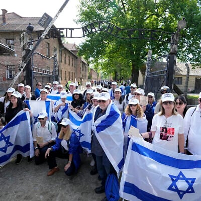 People holding Israeli flags pose for a photo at Auschwitz-Birkenau in Oswiecim, Poland, May 6, 2024 during the annual Holocaust remembrance event, the 'March of the Living' in memory of the six million Jewish victims of the Holocaust victims. (AP Photo/Czarek Sokolowski)