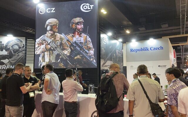 People gather around the booth of Colt, on display at the Defense Services Asia (DSA) exhibition in Kuala Lumpur, Malaysia Tuesday, May 7, 2024. (AP Photo/Syawalludin Zain)