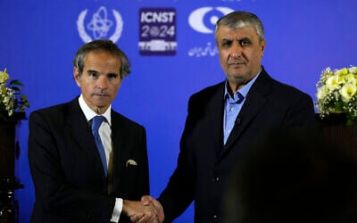 Director General Rafael Grossi of the International Atomic Energy Organization, IAEA, left, and head of Iran's atomic energy department Mohammad Eslami shake hands at the conclusion of their joint press conference after their meeting in the central city of Isfahan, Iran, Tuesday, May 7, 2024. (AP Photo/Vahid Salemi)