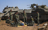 Illustrative: Israeli soldiers work on armored military vehicles at a staging ground near the Israeli-Gaza border, in southern Israel, May 8, 2024. (AP Photo/Tsafrir Abayov)