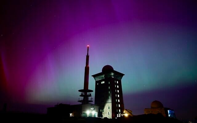 Northern lights appear in the night sky above the Brocken, May 11, 2024, in Schierke, northern Germany. (Matthias Bein/dpa via AP)