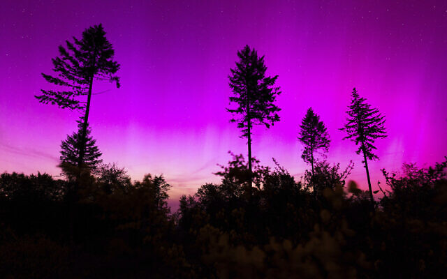 Northern lights appear in the night sky over the Pferdskopf near Treisberg in the Hochtaunus district of Hesse, Germany, May 11, 2024. (Lando Hass/dpa via AP)