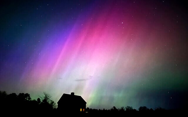 The northern lights flare in the sky over a farmhouse, May 10, 2024, in Brunswick, Maine. (AP Photo/Robert F. Bukaty)