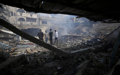 Palestinians look at the destruction after an Israeli strike on a school run by UNRWA where the IDF said it struck a Hamas command room, in Nuseirat, Gaza Strip, May 14, 2024. (AP Photo/Abdel Kareem Hana)