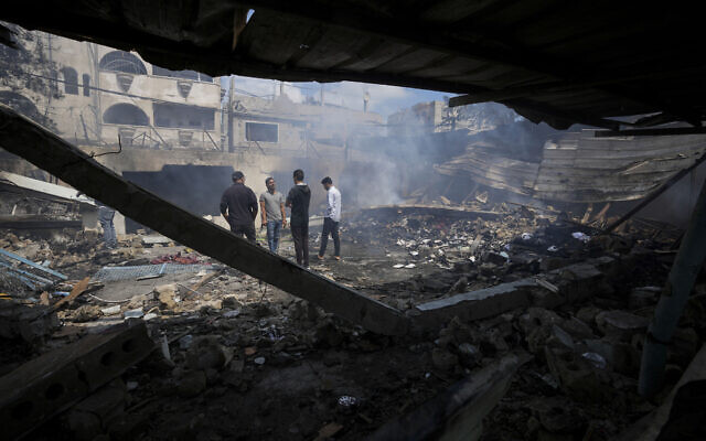 Palestinians look at the destruction after an Israeli strike on a school run by UNRWA, the UN agency for Palestinian refugees, in Nuseirat, Gaza Strip, Tuesday, May 14, 2024. (AP/Abdel Kareem Hana)