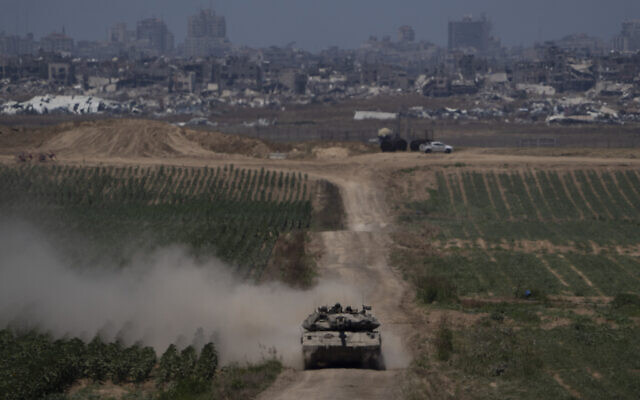 Israeli soldiers move on the top of a tank near the Israeli-Gaza border, as seen from southern Israel, May 16, 2024. (AP Photo/Leo Correa)