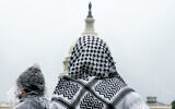 A man wearing a keffiyeh looks at the US Capitol during a pro-Palestinian, anti-Israel rally on May 18, 2024, on the National Mall in Washington. (AP Photo/Jacquelyn Martin)