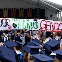 FILE: George Washington University students carry a sign during an anti-Israel protest as George Washington University President Ellen Granberg speaks at a commencement ceremony in Washington, May 19, 2024. (AP Photo/Jose Luis Magana)