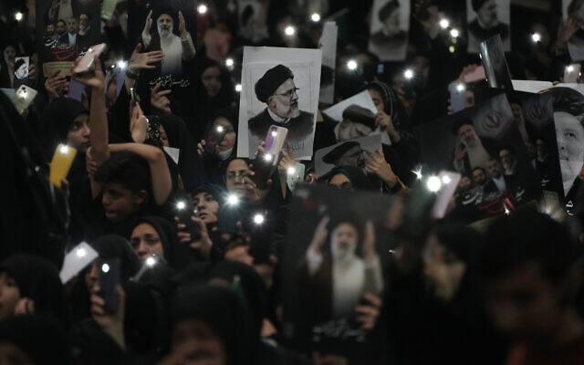 Mourners hold up a posters of the late Iranian President Ebrahim Raisi at the mam Khomeini Grand Mosque in Tehran, Iran, May 21, 2024 during a funeral ceremony for him and his companions who were killed in a helicopter crash on Sunday in a mountainous region of the country's northwest (AP Photo/Vahid Salemi)
