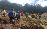 People cross over a landslide area to get to the other side in Yambali village, Papua New Guinea, May 24, 2024.  (Benjamin Sipa/International Organization for Migration via AP)