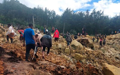 People cross over a landslide area to get to the other side in Yambali village, Papua New Guinea, May 24, 2024.  (Benjamin Sipa/International Organization for Migration via AP)