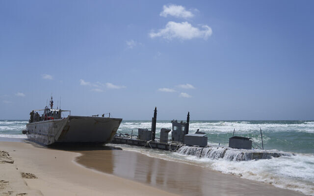 A washed up US Army vessel and a strip of docking area stranded off the coast near Ashdod, May 25, 2024. (AP Photo/Tsafrir Abayov)