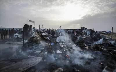 Palestinians look at the destruction after an Israeli strike adjacent to where displaced people were staying in Rafah, Gaza Strip, May 27, 2024. (AP Photo/Jehad Alshrafi)