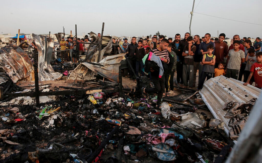 Palestinians look at the destruction after Israeli strike on what the IDF said was a Hamas compound, adjacent to a camp for internally displaced people in Rafah, Gaza Strip, Monday, May 27, 2024. (AP/Jehad Alshrafi)