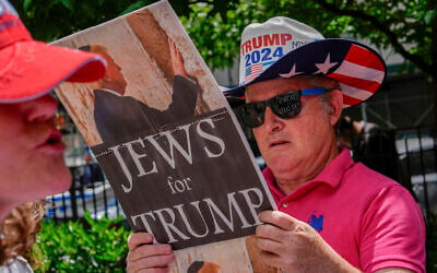 Illustrative: A supporter of former President Donald Trump reads a 'Jews for Trump' sign outside Manhattan Criminal Court, on May 29, 2024, in New York. (AP/Julia Nikhinson) Illustrative: A supporter of former President Donald Trump reads a 'Jews for Trump' sign outside Manhattan Criminal Court, on May 29, 2024, in New York. (AP/Julia Nikhinson)