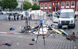 Forensics officers stand behind a smashed stall on the market square in Mannheim, Germany, May 31, 2024. (Uwe Anspach/dpa via AP)
