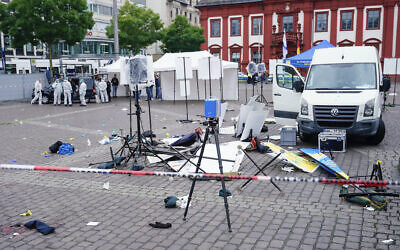 Forensics officers stand behind a smashed stall on the market square in Mannheim, Germany, May 31, 2024. (Uwe Anspach/dpa via AP)