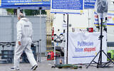 A forensic police officers walks past a smashed stall which had a banner with writing reading 'Stop political Islam' on the market square in Mannheim, Germany, May 31, 2024. (Uwe Anspach/dpa via AP)