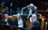 Shas chief MK Aryeh Deri, standing center-right, speaks with Prime Minister Benjamin Netanyahu, right, at the Knesset in Jerusalem on December 6, 2023. Seated are Justice Minister Yariv Levin, center-left, and National Security Minister Itamar Ben Gvir, left. (Yonatan Sindel/Flash90)