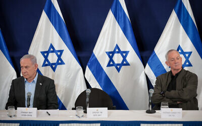 Prime Minister Benjamin Netanyahu (left) sits during a press conference along with Minister Benny Gantz at the Defense Ministry headquarters in Tel Aviv, December 16, 2023. (Noam Revkin Fenton/Flash90)