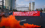 Protesters hold a banner reading 'It's either Rafah or the hostages: Choose life' as they block the Ayalon Highway in Tel Aviv during a demonstration calling for the release of the hostages held by Hamas in Gaza, May 2, 2024. (Dor Pazuelo/Flash90)