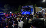 Israeli security forces guard aid trucks making their way to the Gaza Strip while people protest them, on Route 1 between Jerusalem and Tel Aviv, May 6, 2024. (Chaim Goldberg/Flash90)