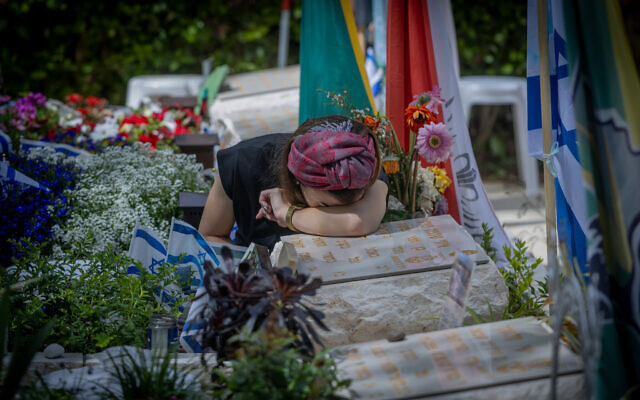 A woman mourns at the grave of a solider killed during the war, Mount Herzl Military Cemetery in Jerusalem, on May 10, 2024 (Chaim Goldberg/Flash90)