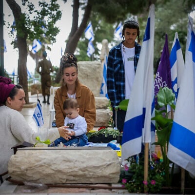 Bereaved families visit the graves of fallen soldier during Memorial Dayat  Mount Herzl Military Cemetery in Jerusalem on May 13, 2024. (Chaim Goldberg/Flash90)