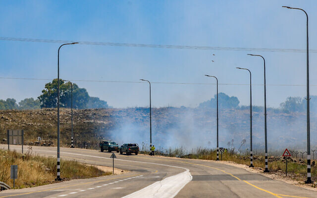 Smoke rises from the side of a road after rockets fired from Lebanon hit an open area in the Golan Heights, May 16, 2024. (David Cohen/Flash90) Smoke rises from the side of a road after rockets fired from Lebanon hit an open area in the Golan Heights, May 16, 2024. (David Cohen/Flash90)
