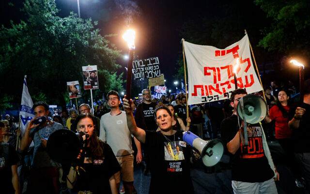Ayala Metzger, daughter-in-law of Hamas hostage Yoram Metzger, leads demonstration alongside other hostage family members for a hostage deal and against the government outside the Prime Minister's Office in Jerusalem, May 18, 2024. (Chaim Goldberg/Flash90)