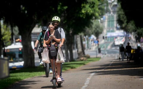 Young Israelis ride an electric scooter in Tel Aviv on May 22, 2024. (Miriam Alster/FLASH90)