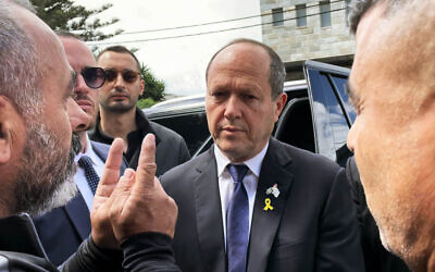 Druze activist Hamud Marzuk makes a point to Economy and Industry Minister Nir Barkat at the entrance to the Druze military cemetery in Isfiya, northern Israel, on May 13, 2024. (Sue Surkes/Times of Israel)